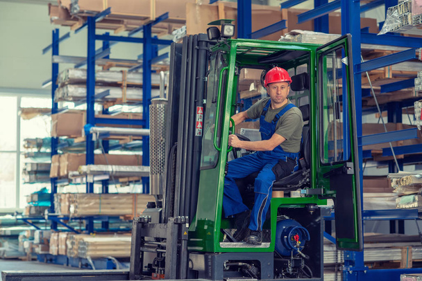 one worker in factory in lift truck with thumb up - Foto, afbeelding