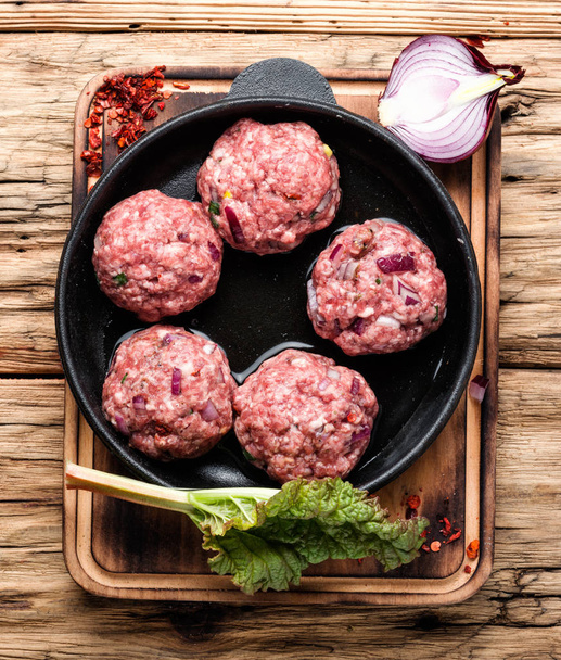 Meat balls from raw beef force-meat in iron cast pan.Meatballs - preparation for cooking - Valokuva, kuva