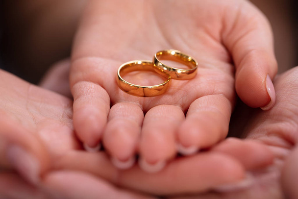 Man And Woman's Hand With Pair Of Golden Engagement Rings - Foto, Imagem