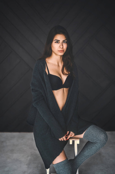 Young brunette in black underwear, knitted knee pads and cardiga - Fotografie, Obrázek