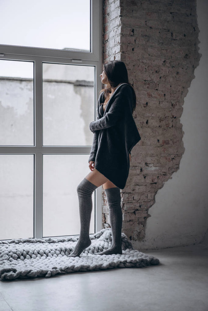 Young brunette in black underwear, knitted knee pads and cardiga - Valokuva, kuva