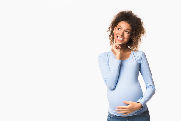 Happy afro pregnant girl dreaming about child - Foto, Imagen