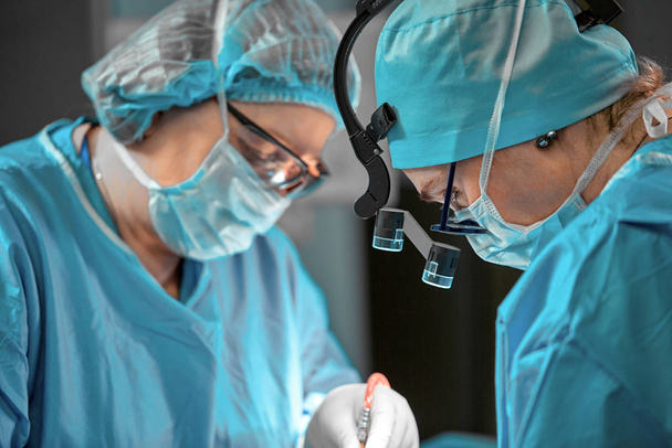 Zespół chirurgów na sali operacyjnej, portrety z bliska. nowoczesna operacja, operacja plastyczna. Przemysł kosmetyczny - Zdjęcie, obraz