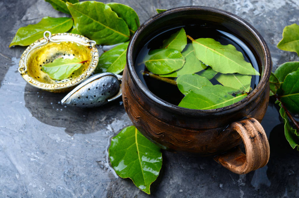 Herbal tea with bay leaf on old wooden background - Foto, Imagen