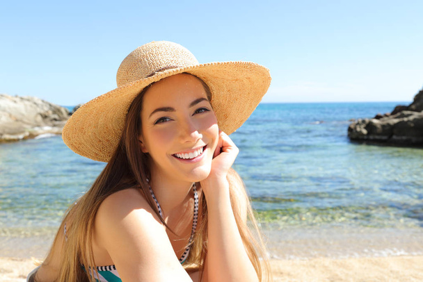 Candid tourist with perfect smile posing on the beach looking at camera on summer vacation - Fotografie, Obrázek
