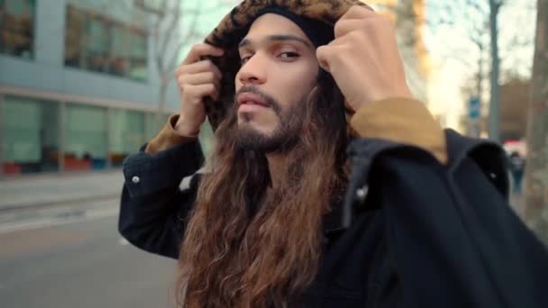 Portré hosszú hajú hipster séta az utcán a modern városban - Felvétel, videó