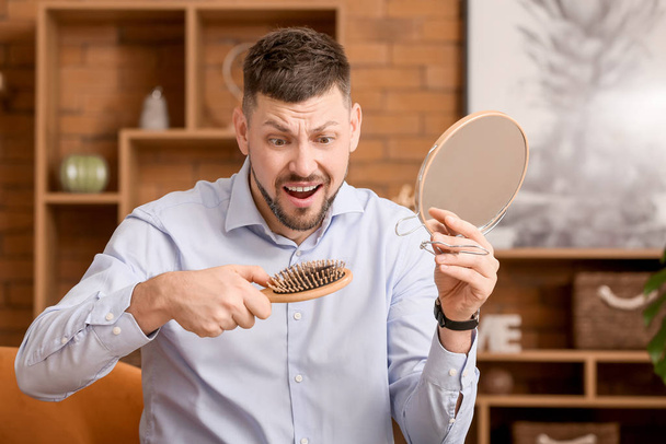 Занепокоєний чоловік з проблемою випадіння волосся вдома
 - Фото, зображення