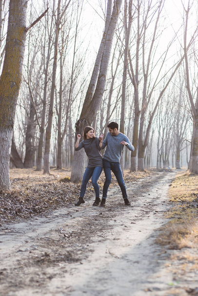 Νεαρό ζευγάρι παίζει στο δάσος το φθινόπωρο / χειμώνα - Φωτογραφία, εικόνα
