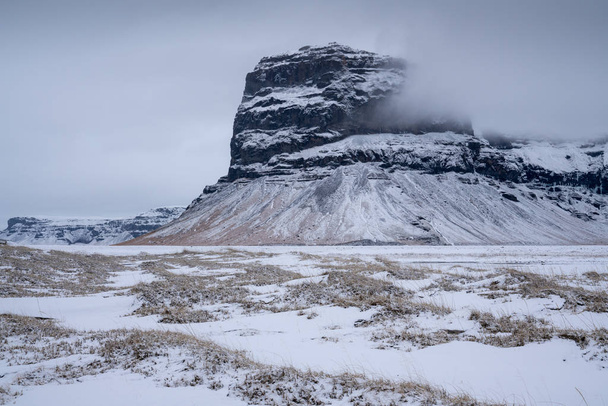 Panoramic landscape along the southern coast of Iceland with snow-covered mountains - Fotoğraf, Görsel