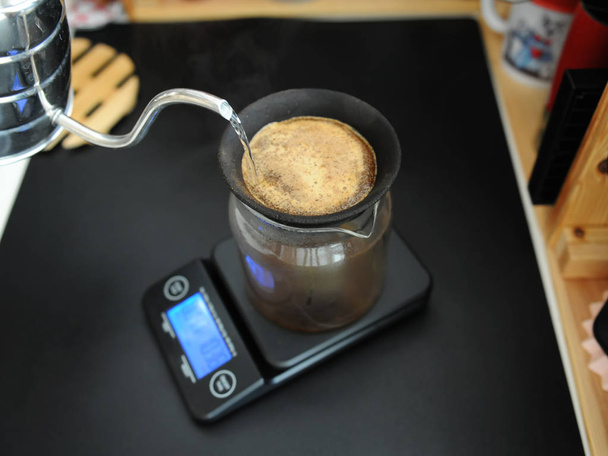 Black porous ceramic paperless coffee filter on glass jug. Gooseneck kettle. Electronic scale. Manual brewing still life - Photo, Image