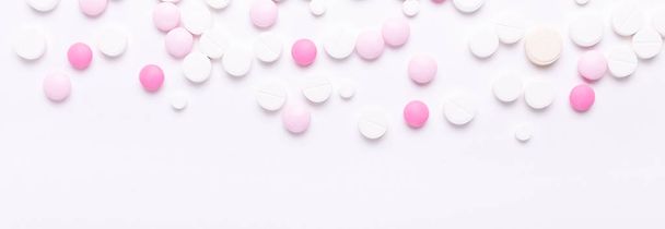 Pink and white pills on white background. Heap of assorted various medicine tablets and pills. Horizontal banner. - Фото, зображення