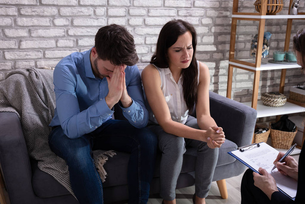 Psychologist Talking With Depressed Young Couple About Mental Condition In Home - Foto, Bild