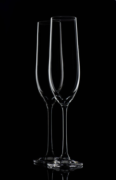 Two empty champagne glasses on black background - Foto, afbeelding