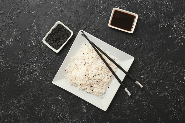 Talerz z gotowanym ryżem i sosem sojowym na ciemnym tle - Zdjęcie, obraz