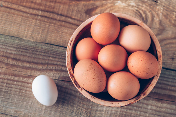 Mísa syrových kuřecích vajec na dřevěném pozadí - Fotografie, Obrázek