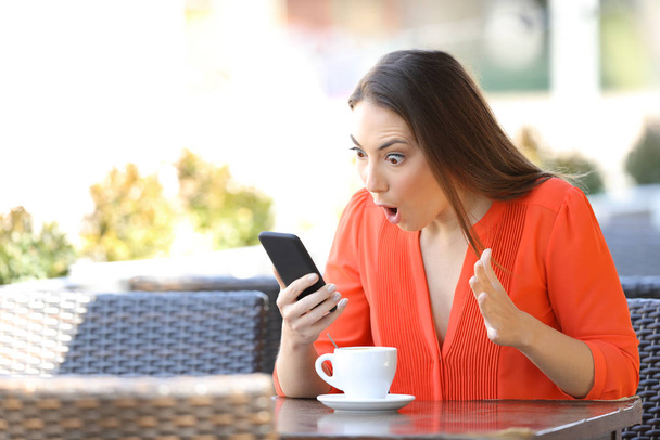 Дивовижна жінка перевіряє вміст смартфона, знаходить хороші новини в терасі кав'ярні
 - Фото, зображення