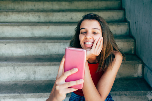 Teen girl sticking out tonge for a selfie - Foto, Imagen