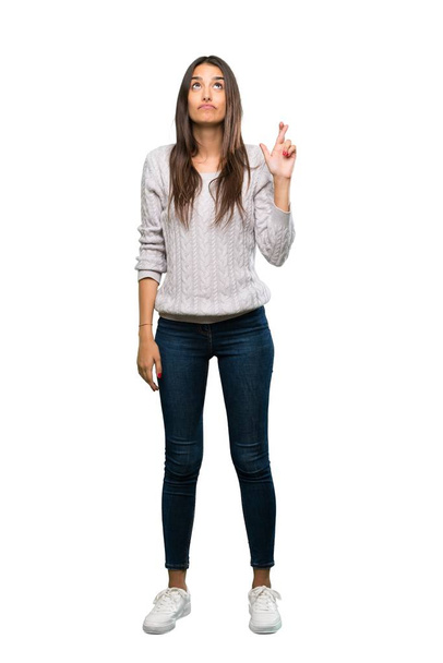 A full-length shot of a Young hispanic brunette woman with fingers crossing and wishing the best over isolated white background - Photo, image