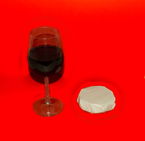 Cheese And Glass Of Red Wine on red background - Photo, Image