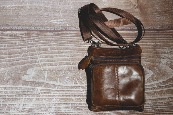 mens leather shoulder bag on wooden background - Фото, изображение