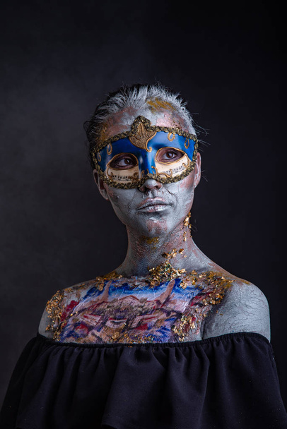 Portrait of a young masked woman with creative makeup on the theme of Venice Carnival - Foto, afbeelding