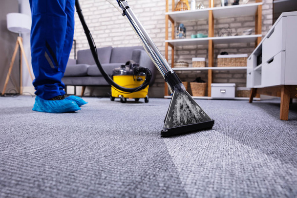 Human Cleaning Carpet In The Living Room Using Vacuum Cleaner At Home - 写真・画像