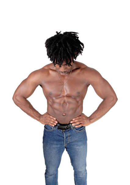A handsome African man standing from the front, looking down with.his fuzzy hair and shirtless, isolated for white background. - Фото, изображение
