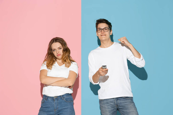 Young emotional man and woman on pink and blue background - Foto, Bild