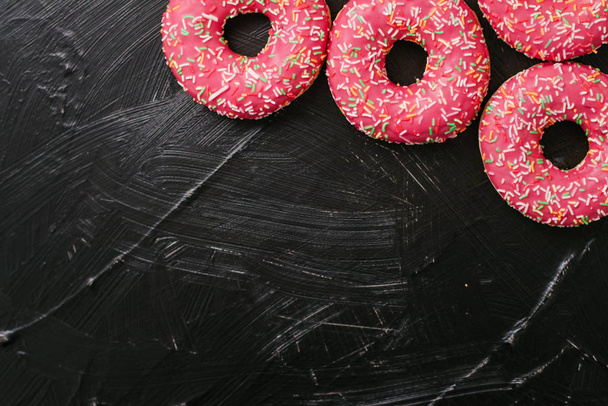 Frosted sprinkled donuts, sweet pastry dessert on rustic wooden  - Photo, Image