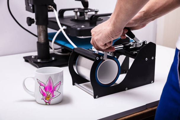 Man printing on coffee mugs in workshop - Fotografie, Obrázek