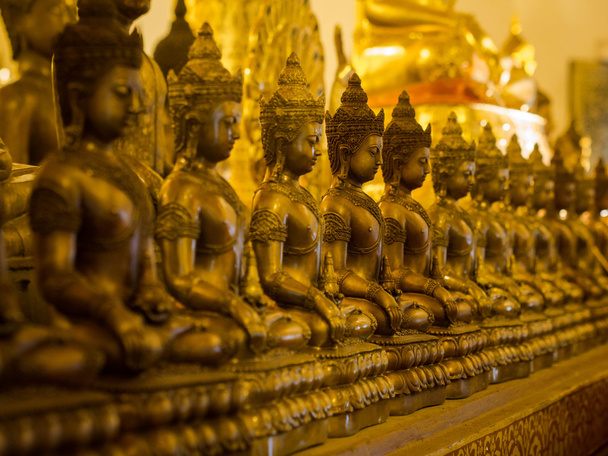 Ряд сидящих статуй Будды в буддийском храме
 - Фото, изображение