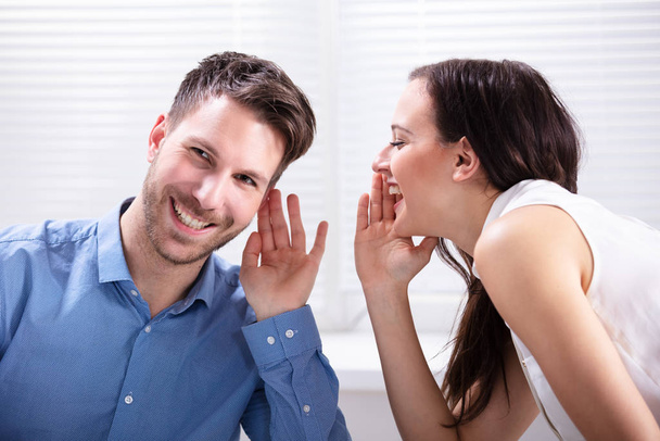 Portrait Of Happy Woman Whispering Secret Or Interesting Gossip To Handsome Man In His Ear - Fotografie, Obrázek