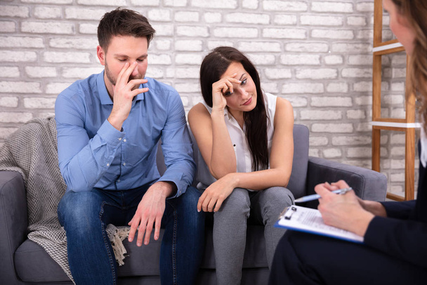 Psychologist Talking With Depressed Young Couple About Mental Condition In Home - 写真・画像