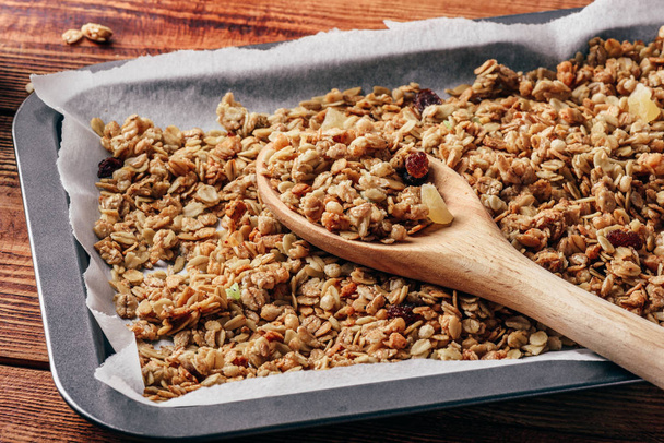 Homemade granola on baking sheet with wooden spoon - Zdjęcie, obraz