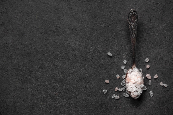 Κουτάλι με αλάτι Ιμαλαΐων σε μαύρο τραπέζι - Φωτογραφία, εικόνα