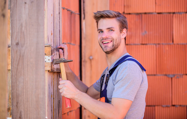 Engineer with hammer tool. Worker with hammer brick wall background. Building and construction. General maintenance and repair workers are hired for maintenance and repair tasks. Use hammer - Foto, imagen