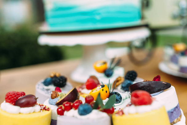 Torta bogyókkal és gyümölcsökkel egy ünnepélyesen díszített asztalon.Candy bar - Fotó, kép