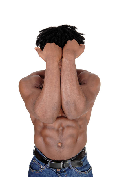 A handsome African man standing from the front, holding booths arms.over his face, shirtless, isolated for white background. - Foto, imagen