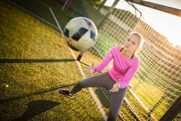 Teen female goalie catching a shot during a soccer game - Fotoğraf, Görsel