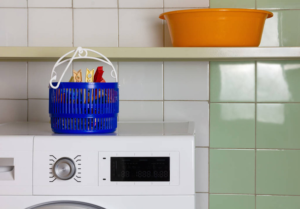 Çamaşır makinesinin tepesindeki çamaşır mandalları için sepet - Fotoğraf, Görsel