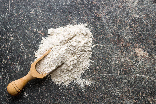 Whole grain wheat flour in wooden scoop. - Foto, Bild