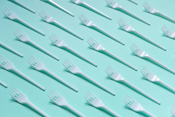 Plastic white forks on pastel blue background - Fotó, kép