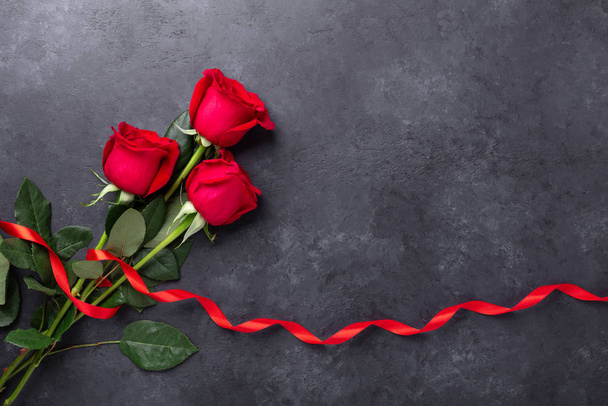 Red rose flowers bouquet on black stone background Valentine's day greeting card - Foto, imagen