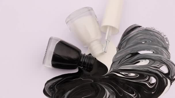 white and black lipsticks flow on a white background and mix together to form a pattern - Footage, Video