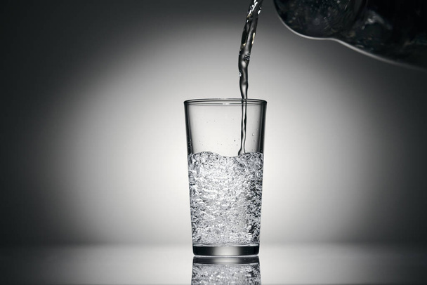 лиття ігристої води в склянці на темному фоні
 - Фото, зображення