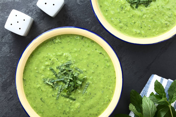 Fresh homemade cream of green pea and mint soup in bowls, garnished with stripes of mint leaves (Selective Focus, Focus on the soup) - Photo, Image