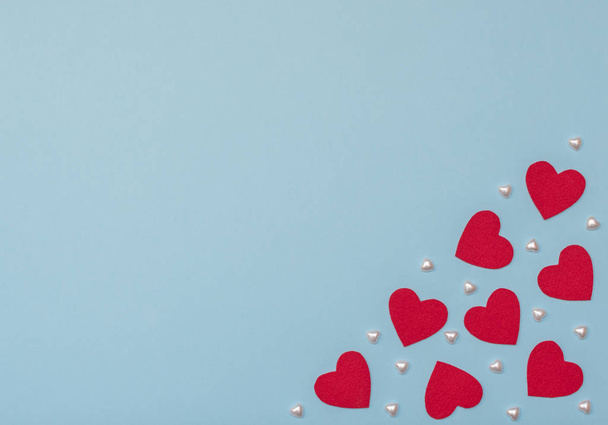 Valentine's Day blue background with red and pearl hearts. Valentine greeting card. Flat lay style with copy space.	 - 写真・画像