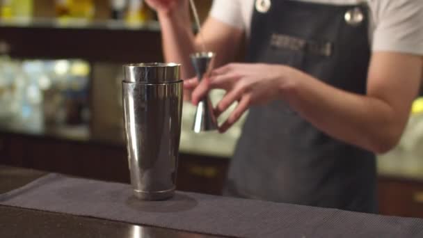 Barkeeper gießt verschiedene Sirupe in Schnapsglas und Shaker  - Filmmaterial, Video