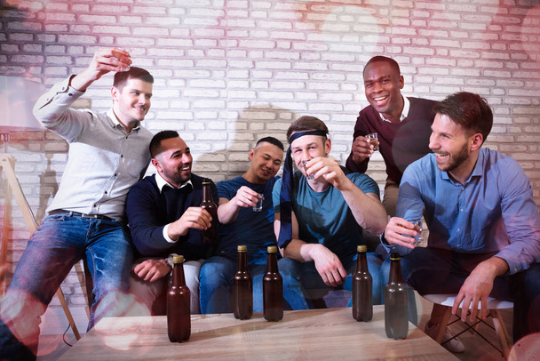 Група веселих молодих чоловіків, що тостів з Текілою в нічному клубі - Фото, зображення