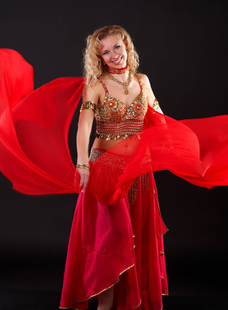 Young blonde belly dancer in red. - Fotó, kép